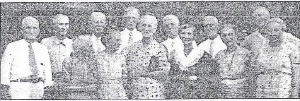 A pre-1941 photo of 13 of the 17 children of William and Synthelia (Cely) DeMar. Longevity runs in the DeMar family, and all 13 lived to be in their 80's and 90's, and one, James, lived to be 102. From left are: (front row): Ann Marie Denman, Sallie Chamberlain, Jennie Stevens, Emma Armstrong, Elizabeth ("Lib") Heltmeyer, Clara Symington, (back row): Joseph Frank, Will, James, Isaac, John, Clint, and Clyde DeMar.
